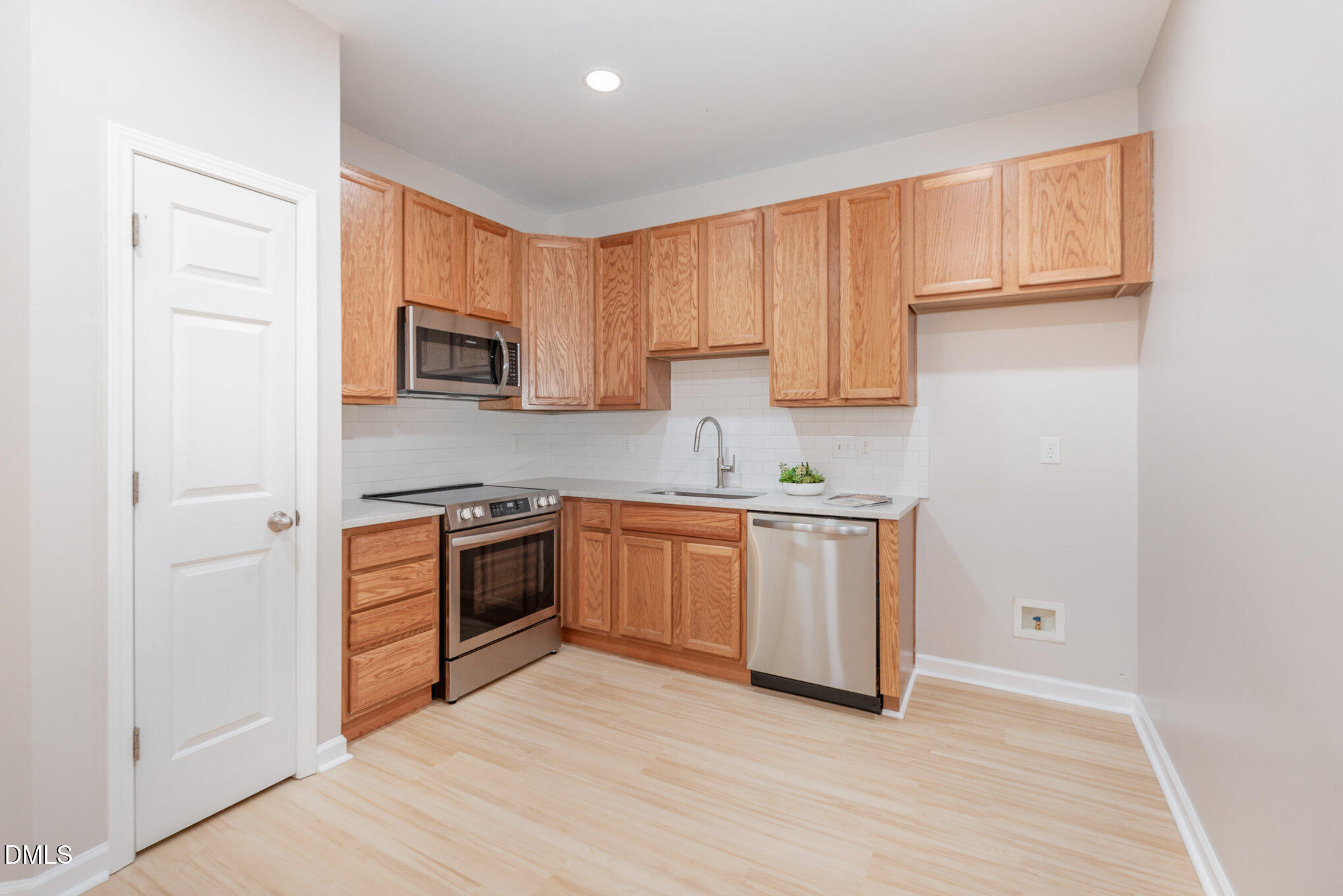 311 Gilman Lane, Unit 107 Raleigh, NC 27610 - Photo 5 of 21 a kitchen with a refrigerator stove top oven and sink