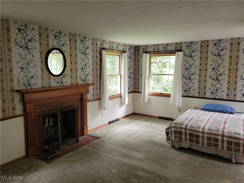29119 Edgewood Road Bay Village, OH 44140 - Photo 21 of 40 Bedroom with a brick fireplace, carpet floors, wallpapered walls, and a textured ceiling