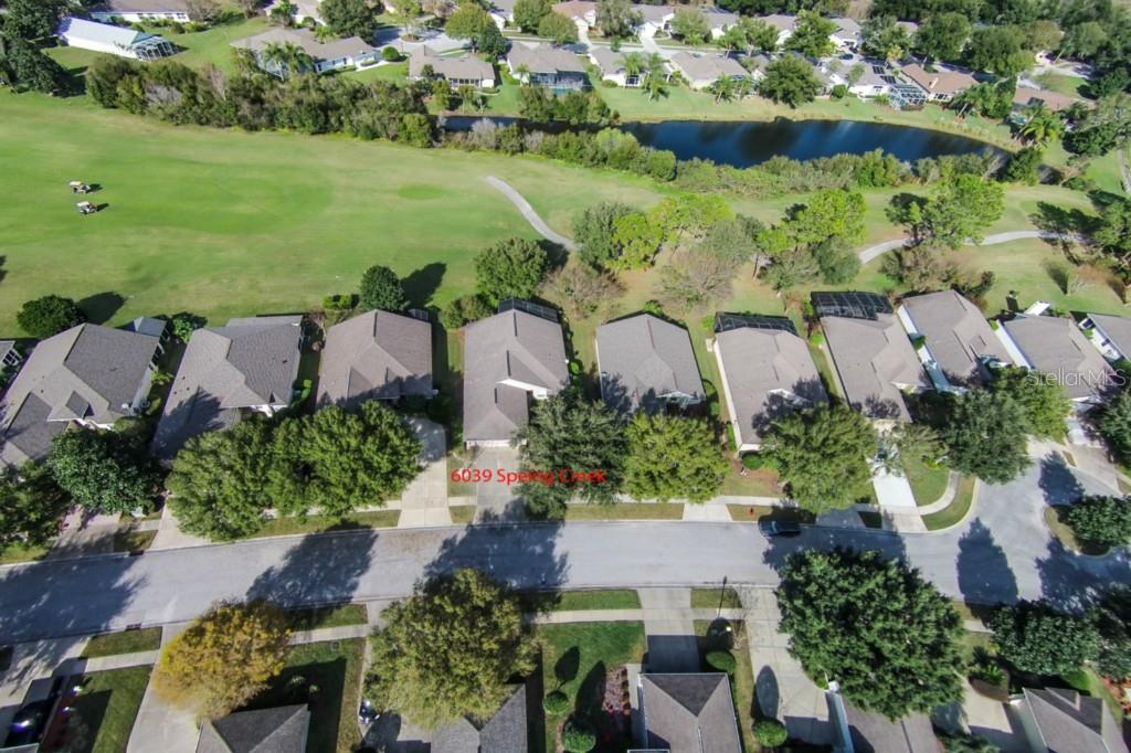 an aerial view of ocean with residential house lake and trees all around