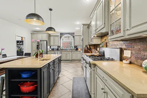 a kitchen with stainless steel appliances granite countertop a sink a stove and a wooden floors
