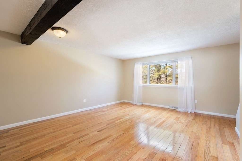20 Hemlock Circle, Unit 20 Millis, MA 02054 - Photo 4 of 27 an empty room with wooden floor and windows