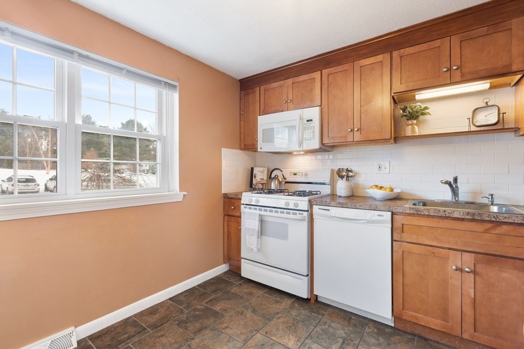 20 Hemlock Circle, Unit 20 Millis, MA 02054 - Photo 8 of 27 a kitchen with stainless steel appliances granite countertop a sink and cabinets with wooden floor