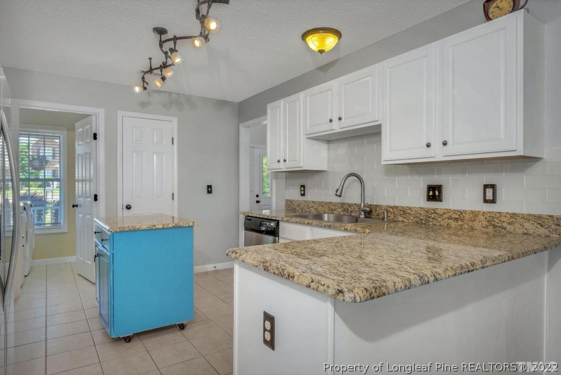 226 Linden Road Cameron, NC 28326 - Photo 13 of 36 a kitchen with granite countertop a sink a stove and cabinets