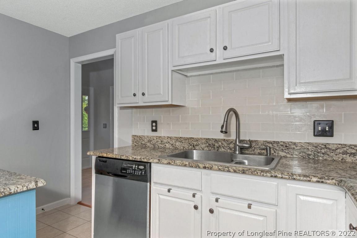 226 Linden Road Cameron, NC 28326 - Photo 14 of 36 a kitchen with granite countertop white cabinets and a sink