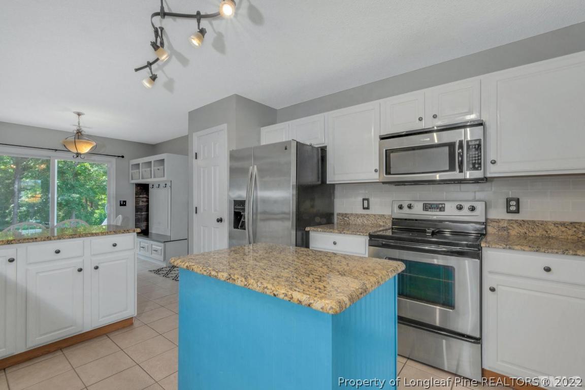 226 Linden Road Cameron, NC 28326 - Photo 16 of 36 a kitchen with stainless steel appliances granite countertop a stove a sink and a refrigerator