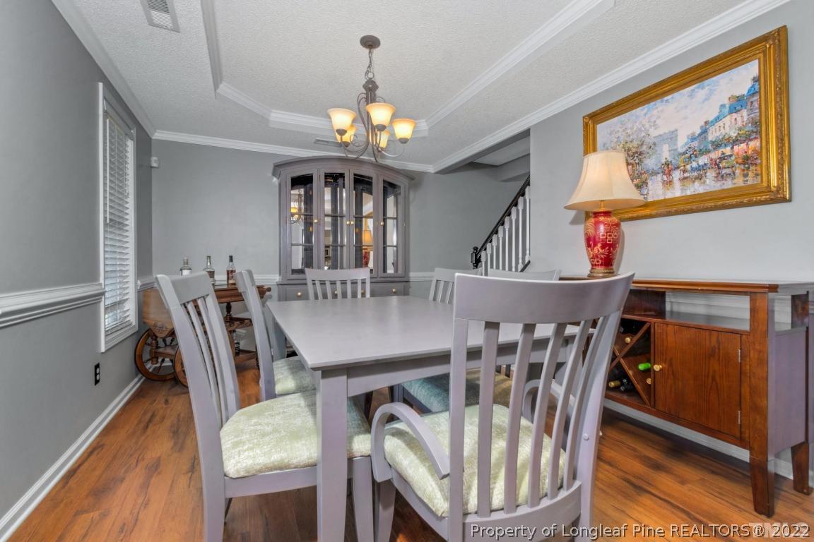 226 Linden Road Cameron, NC 28326 - Photo 17 of 36 a view of a dining room with furniture chandelier and wooden floor