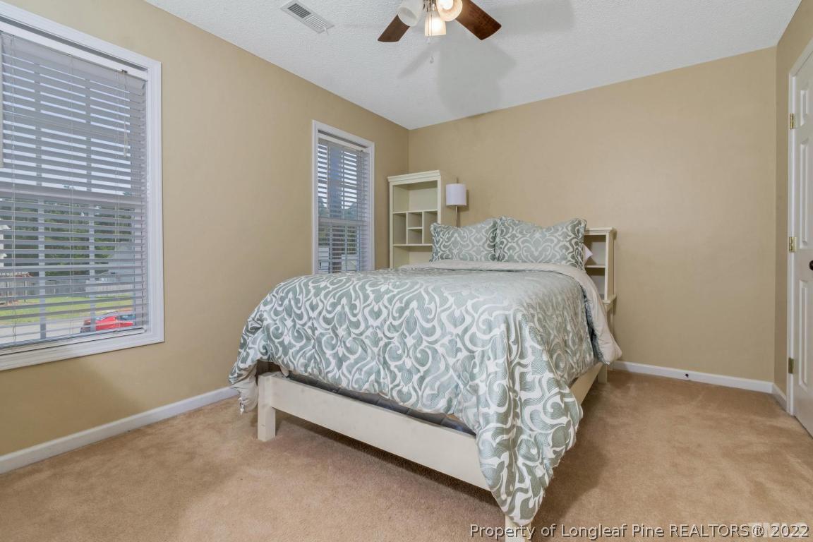 226 Linden Road Cameron, NC 28326 - Photo 22 of 36 a bedroom with a bed and a ceiling fan
