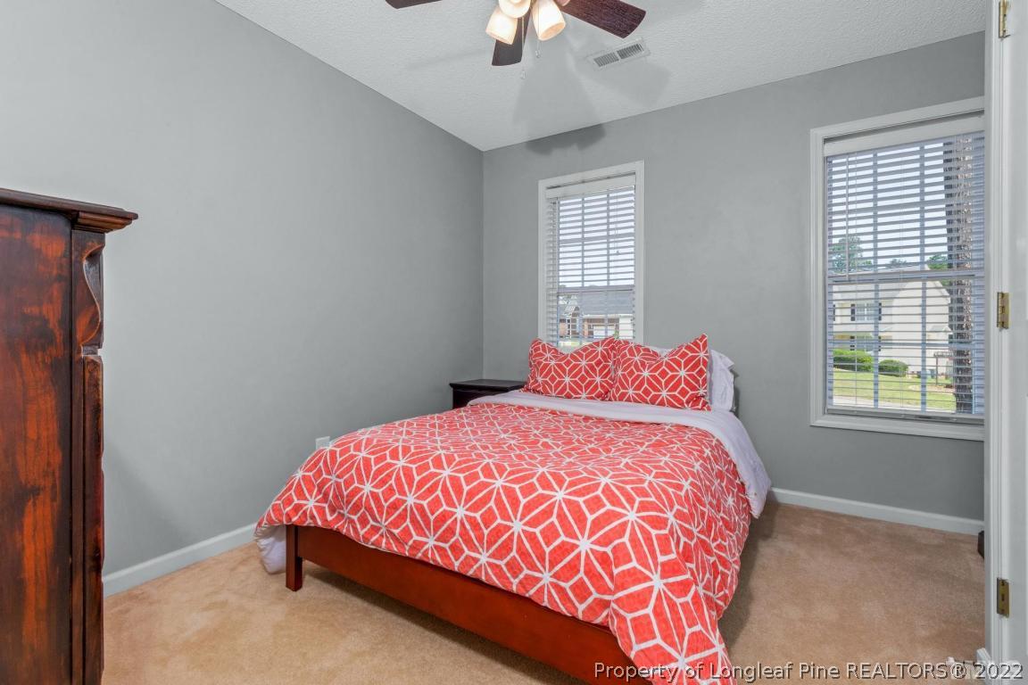 226 Linden Road Cameron, NC 28326 - Photo 24 of 36 a bedroom with a bed and a chandelier fan
