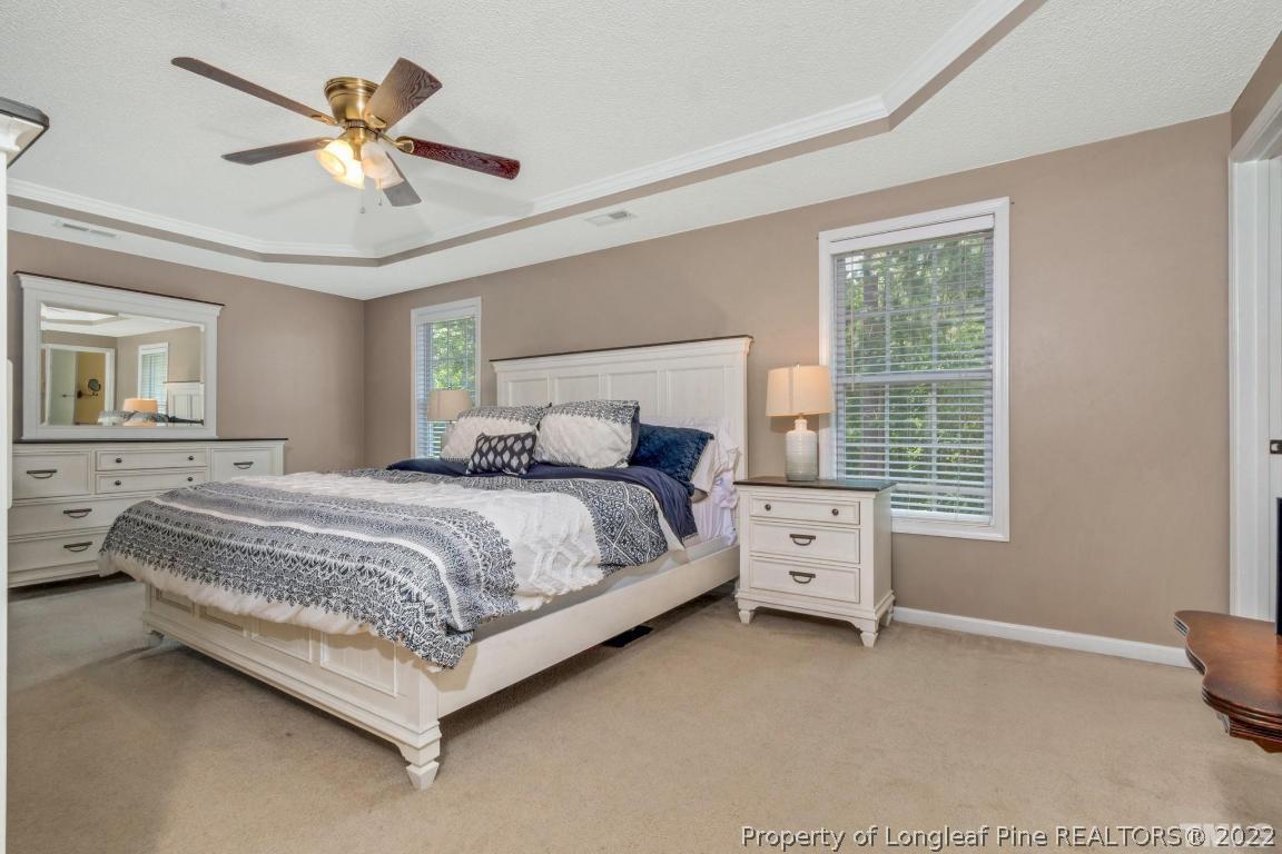 226 Linden Road Cameron, NC 28326 - Photo 28 of 36 a bedroom with a large bed and a chandelier