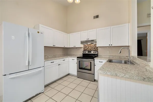 a kitchen with granite countertop cabinets stainless steel appliances and a sink