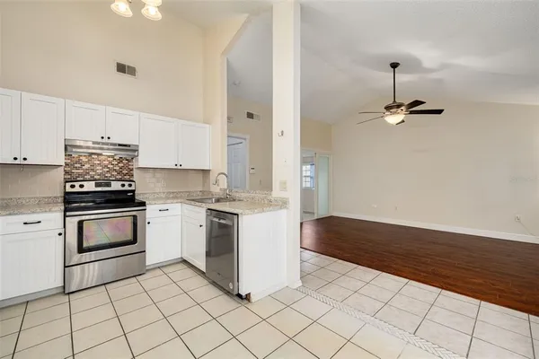 a kitchen with a stove cabinets and wooden floor