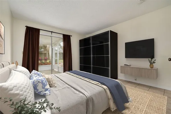 a bedroom with a bed tv and a window