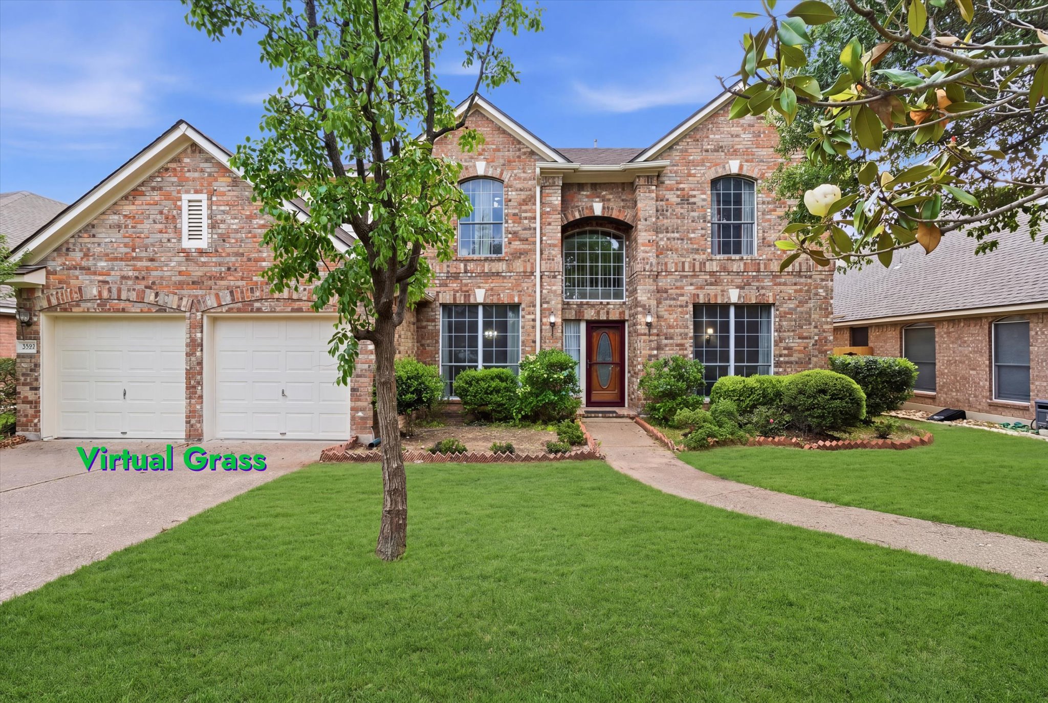 The property features a brick exterior, a two-car garage, and a well-maintained lawn with a paved walkway leading to the front entrance