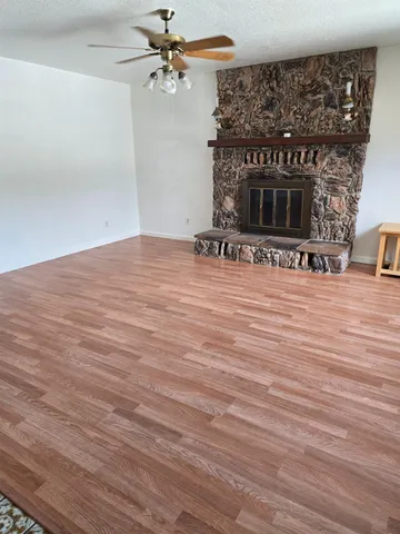 a view of a livingroom with wooden floor and a fireplace