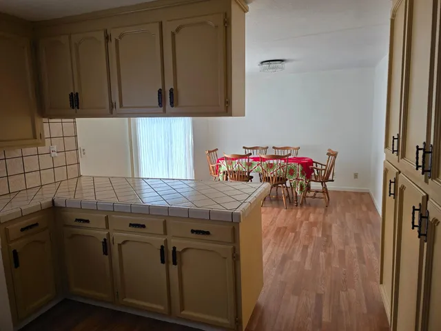 a kitchen with granite countertop white cabinets and wooden floor