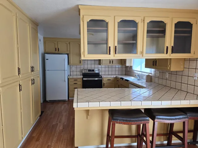 a kitchen with a table chairs refrigerator and cabinets