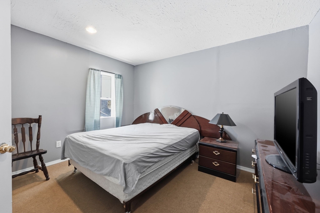 875 North Main Street Randolph, MA 02368 - Photo 13 of 42 a bedroom with a bed and a flat screen tv