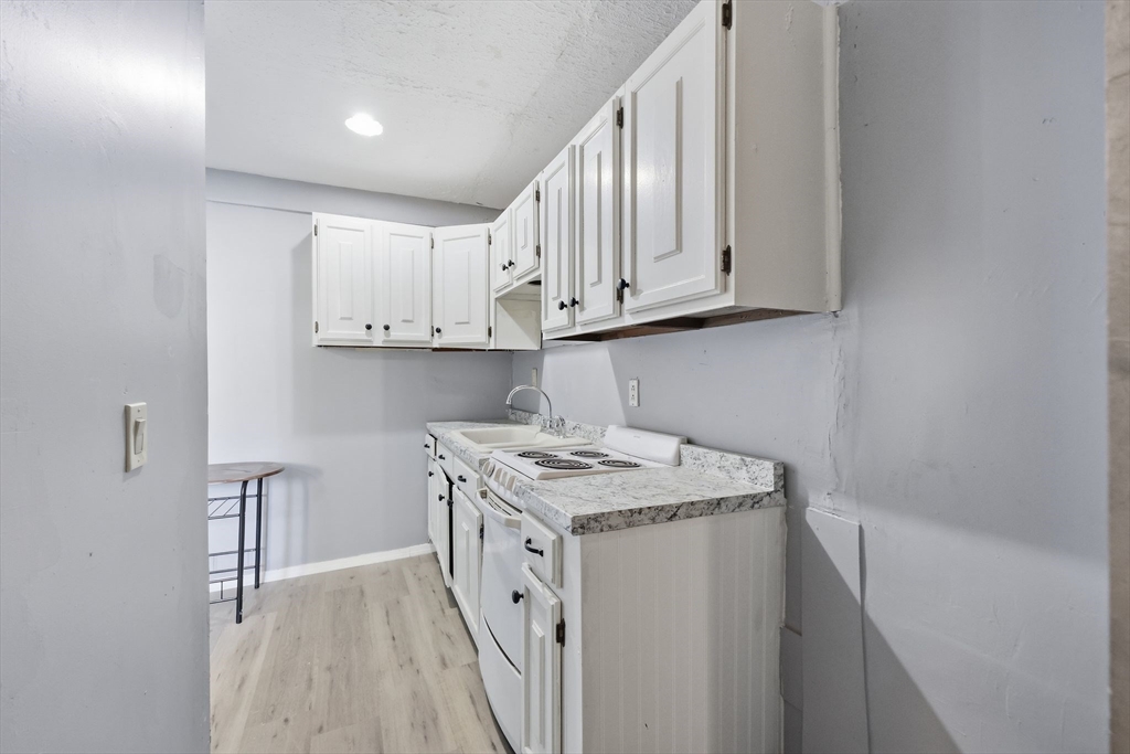 875 North Main Street Randolph, MA 02368 - Photo 16 of 42 a view of kitchen with white cabinets and stainless steel appliances