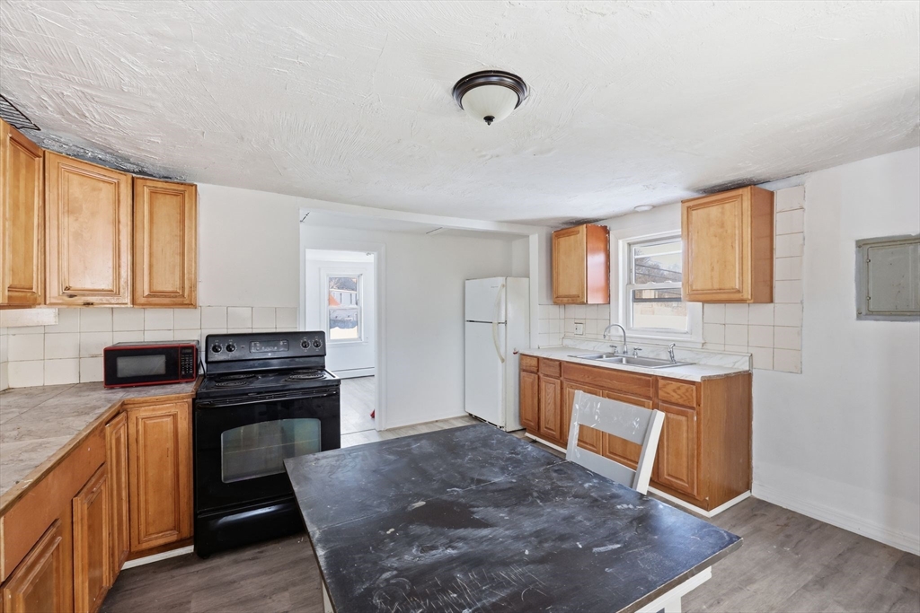 875 North Main Street Randolph, MA 02368 - Photo 28 of 42 a kitchen with stainless steel appliances granite countertop a stove a sink and a refrigerator