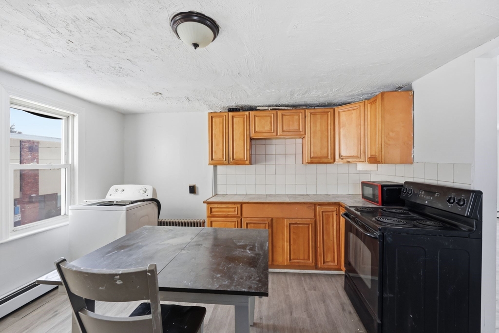 875 North Main Street Randolph, MA 02368 - Photo 30 of 42 a kitchen with a table chairs sink and cabinets