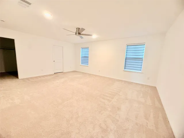 an empty room with a ceiling fan and a window