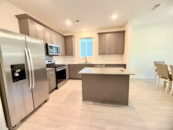 a kitchen with stainless steel appliances granite countertop a stove a sink dishwasher a refrigerator and a oven