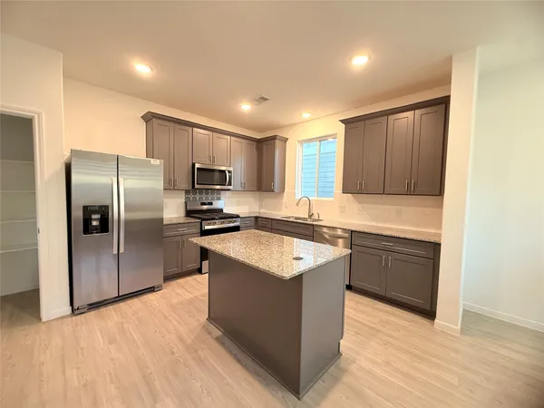 a kitchen with a sink a stove and cabinets