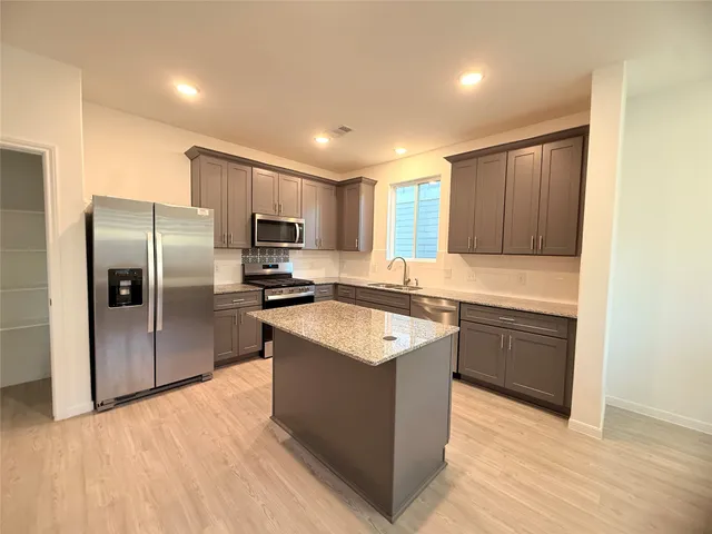 a kitchen with a sink a stove and cabinets