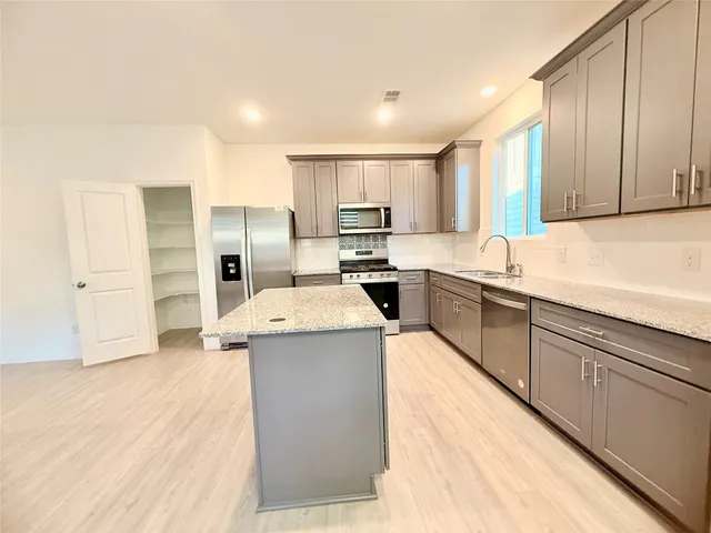 a large kitchen with stainless steel appliances granite countertop a sink counter space and stainless steel appliances