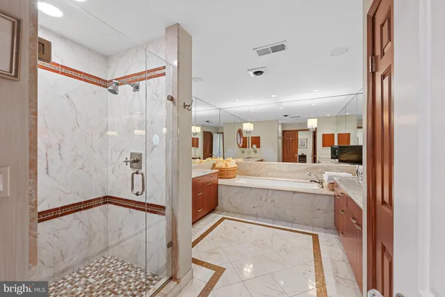 a bathroom with a tub shower sink and mirror