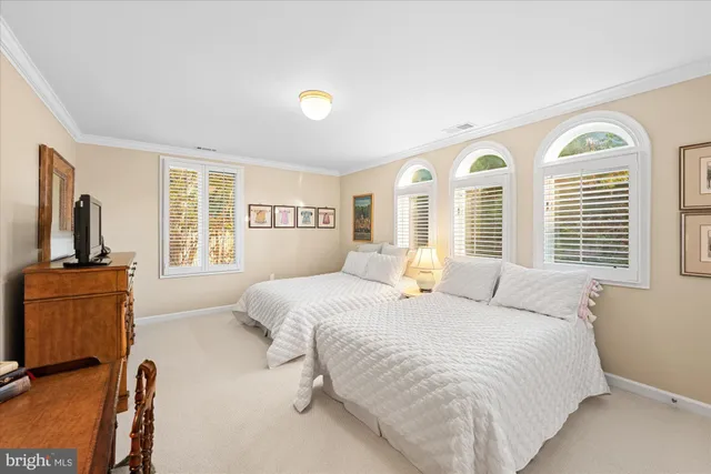 a bedroom with a large bed and windows