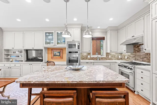 a kitchen with stainless steel appliances granite countertop a stove top oven a sink a counter space and cabinets