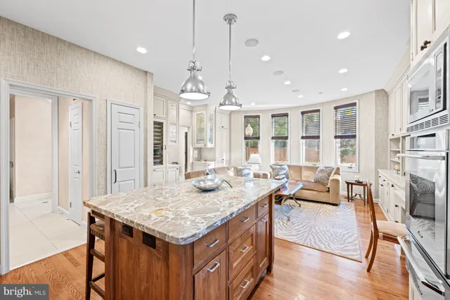 a view of a a dining room and livingroom with furniture wooden floor a rug a flat screen tv a rug and a chandelier