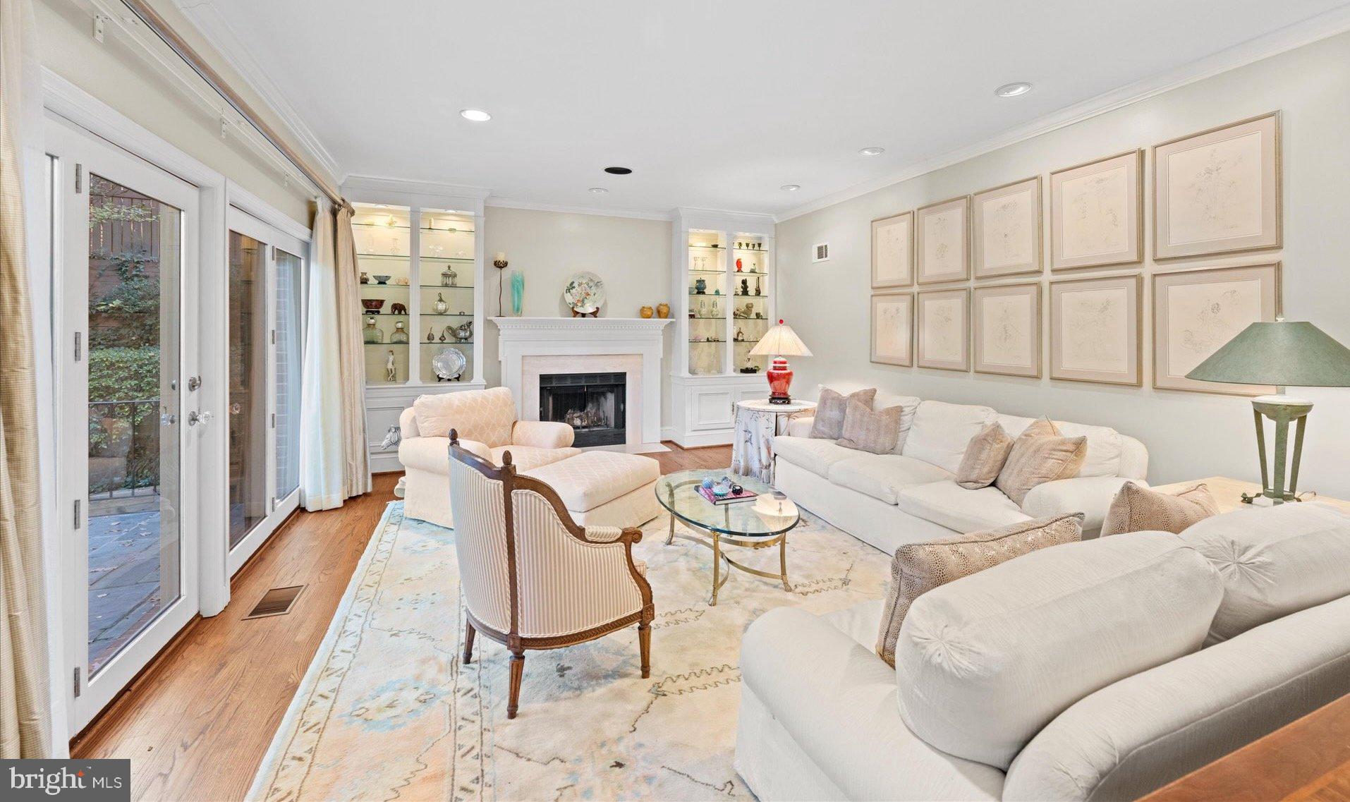 4616 Foxhall Crescent Northwest Washington, DC 20007 - Photo 7 of 21 a living room with furniture a fireplace and a floor to ceiling window