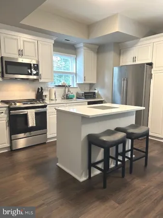 a stove top oven sitting inside of a kitchen