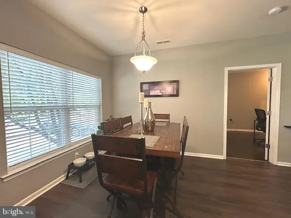 a living room with furniture kitchen view and a large window