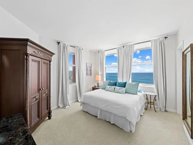 a bedroom with a bed dresser and a large mirror