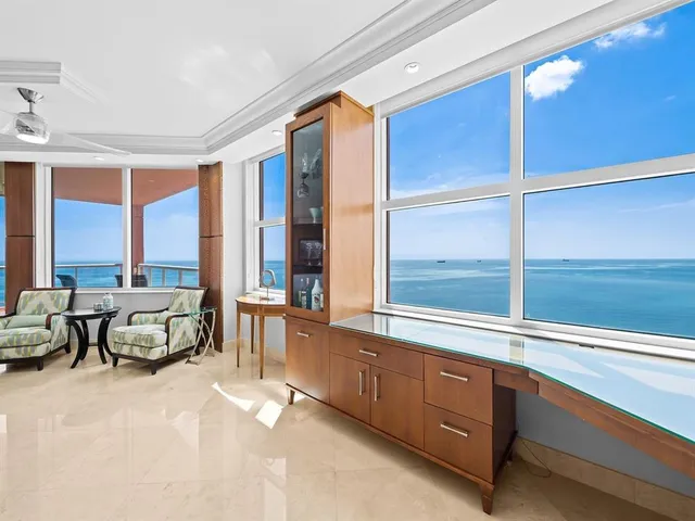 a living room with furniture and large windows