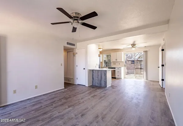 a view of a kitchen with wooden floor and a ceiling fan