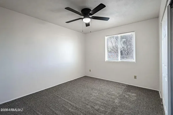 a view of empty room with closet and ceiling fan