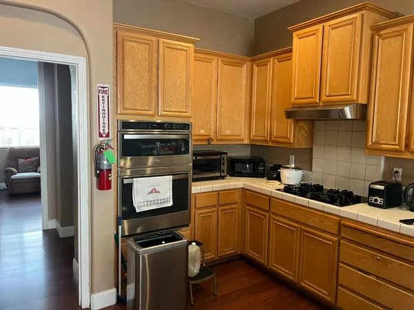 a kitchen with stainless steel appliances a stove a sink and white cabinets