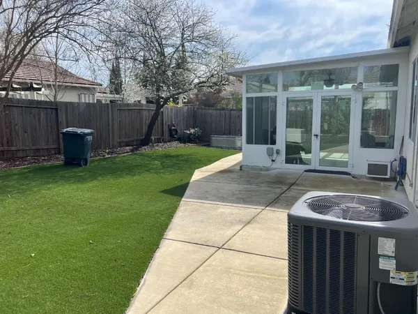 a view of a backyard with table and chairs and wooden fence