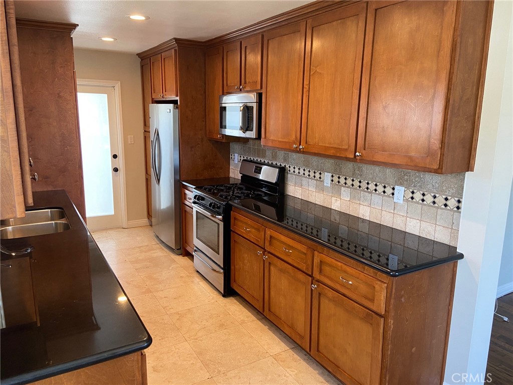 3603 148th Place Hawthorne, CA 90250 - Photo 6 of 19 a kitchen with granite countertop wooden cabinets and stainless steel appliances