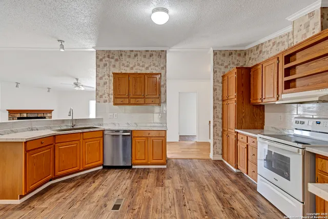 a kitchen with stainless steel appliances granite countertop a sink stove and refrigerator