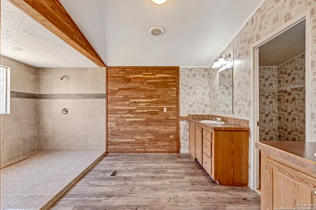 an empty room with wooden floor and a ceiling fan
