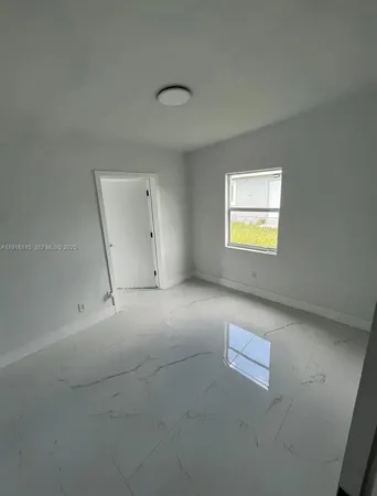 en empty room with windows and entrance