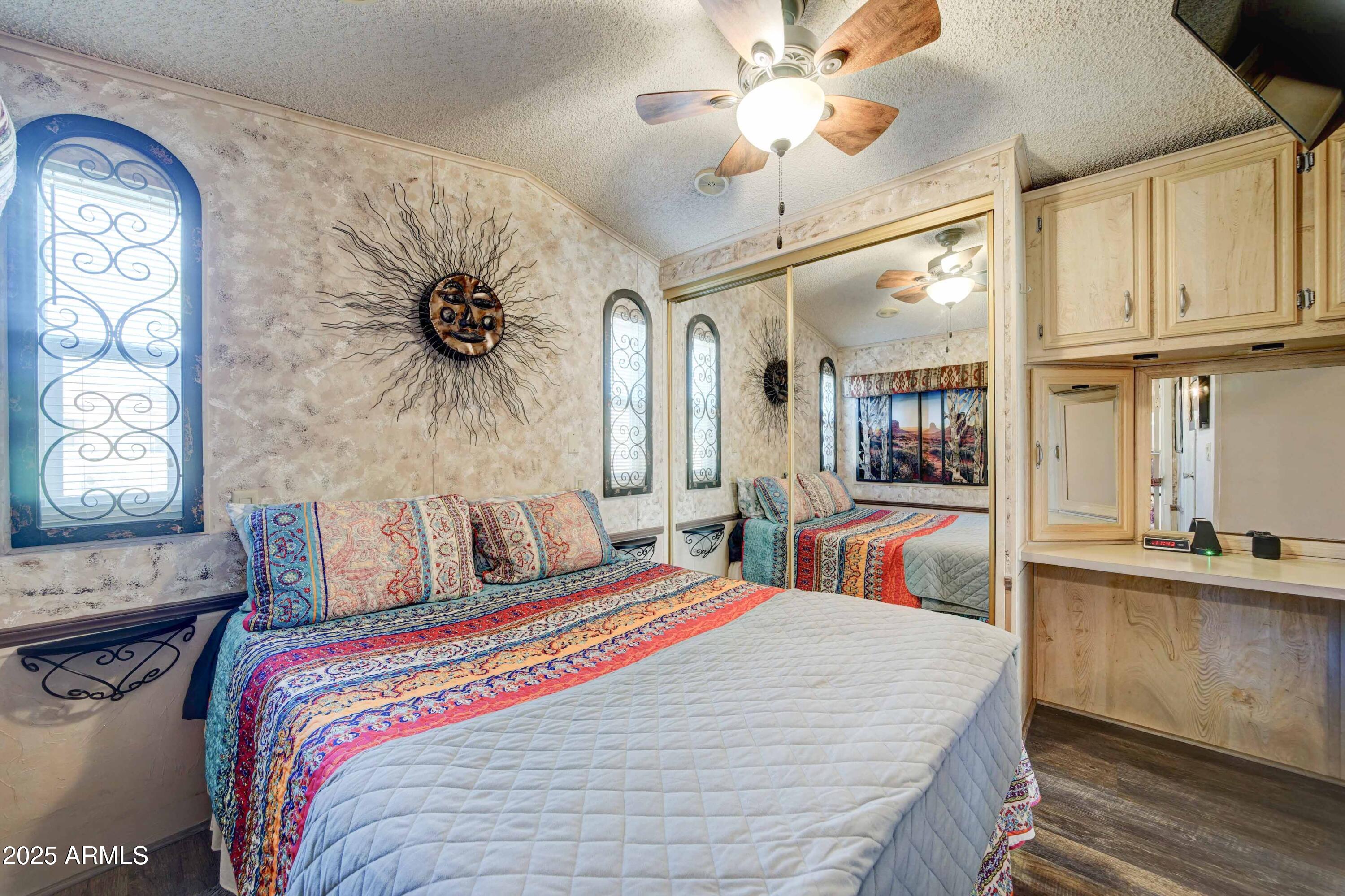 111 South Greenfield Road, Unit 633 Mesa, AZ 85206 - Photo 13 of 32 a bedroom with bed and a chandelier
