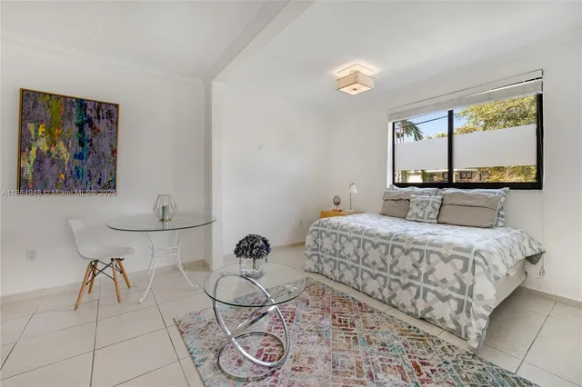 a bedroom with a bed and painting on the wall