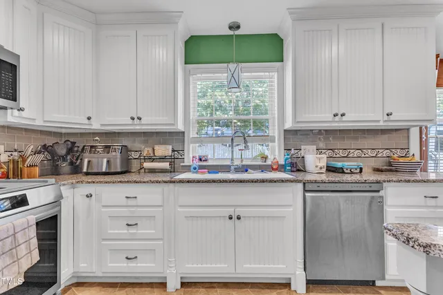 a kitchen with kitchen island granite countertop a stove a sink and a refrigerator