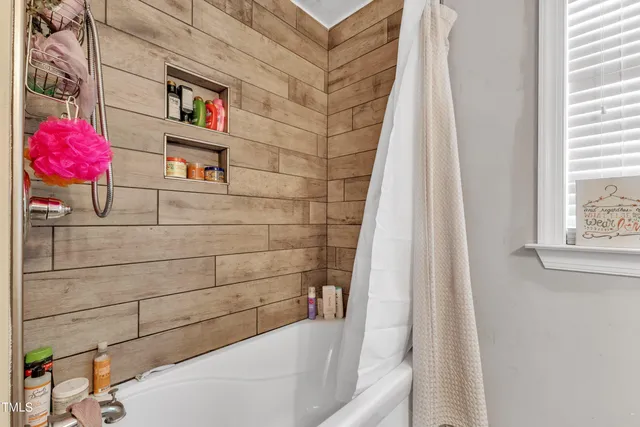 a bathroom with a granite countertop sink a toilet a mirror and shower
